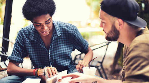 A mentor and mentee sitting at a table working on a project