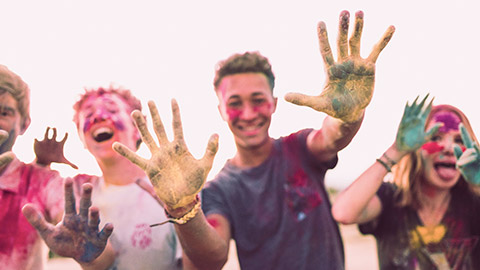 A group of youth taking part in an outdoor activity involving lots of coloured dyes