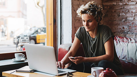 A hipster youth worker sitting in a cafe developing a mentoring program