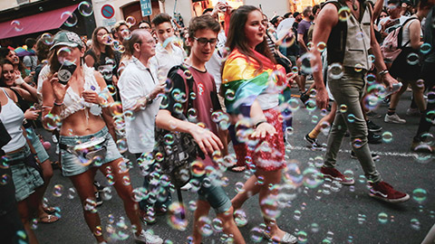 A gay pride march in a city with varying age groups visible