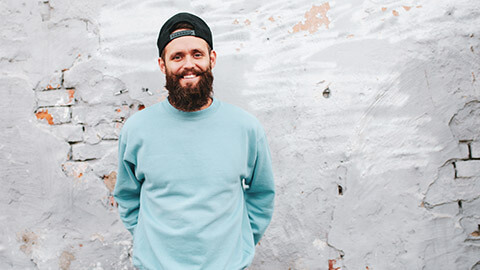 A smiling youth worker standing in front of a wall