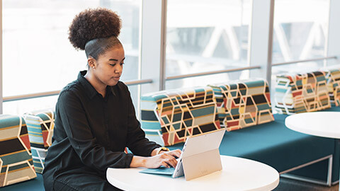 A youth worker writing a project plan on a laptop