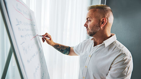 A youth worker writing out a plan on a whiteboard