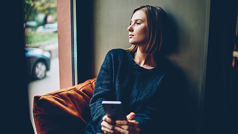 A youth worker deep in thought looking out a window