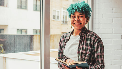 A smiling youth worker standing near a glass window