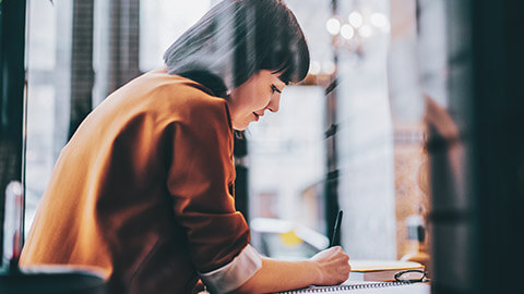 A youth worker writing down a self-care plan in a notebook