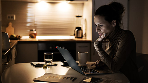 Pensive young woman calculating her budget and working on home finances at the table.