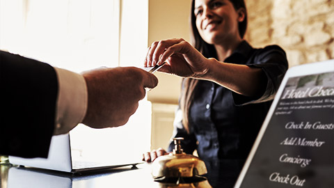 A person giving loyalty card to hotel receptionist