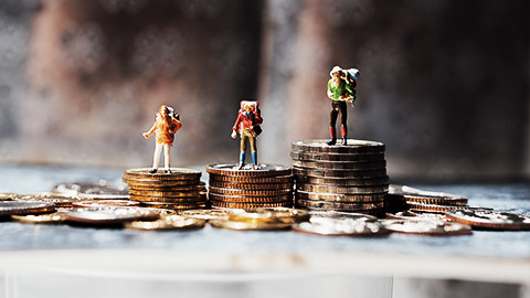 Miniature people, group of travelers standing on stack coins