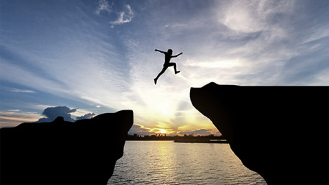 Man jump through the gap between hill.man jumping over cliff