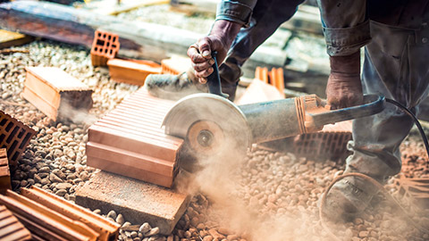 Close view of angle grinder cutting brick