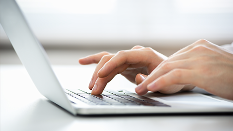 Close-up of hands of business man typing on a laptop