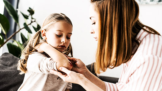 a child with an arm wound being tended to