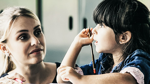 an educator holding closely a student while two other students on her side