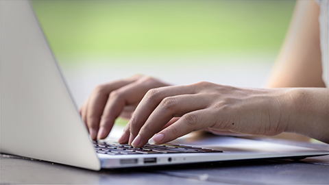 close-up of woman's hand typing on a laptop