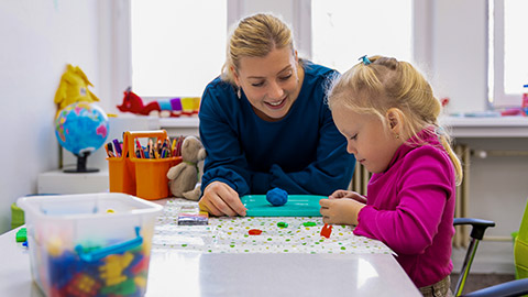 girl playing doing sensory playful exercises with her teacher