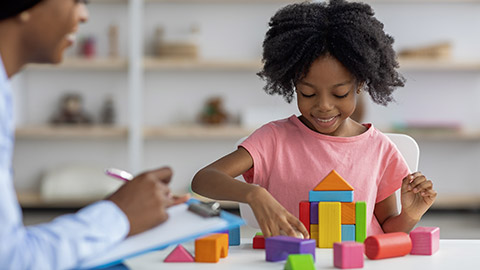 child development specialist observing cheerful child preschooler