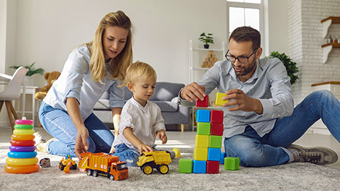 family staying at home and engaging their little kid in fun games