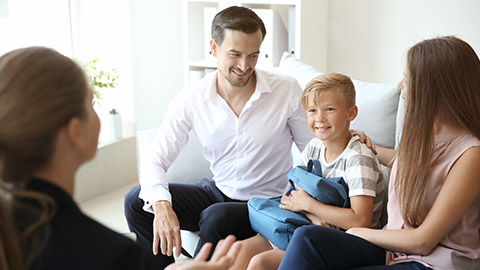 couple and their son meeting with teacher