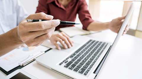 man and woman working on laptop