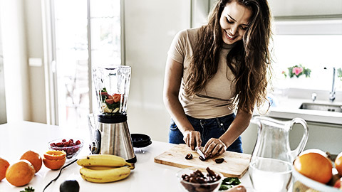 A person cutting fruits in a kitchen