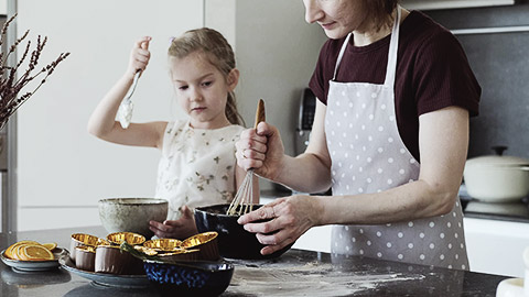 A woman and girl having an activity in the kitchen