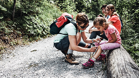 A person applying first aid on a child outdoors