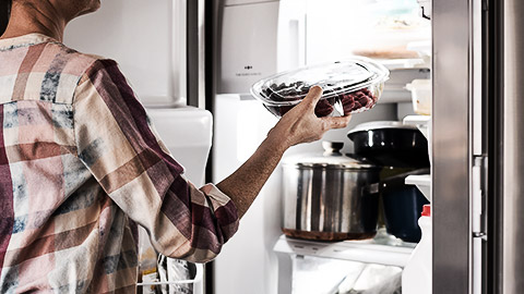 A person putting food in refrigirator