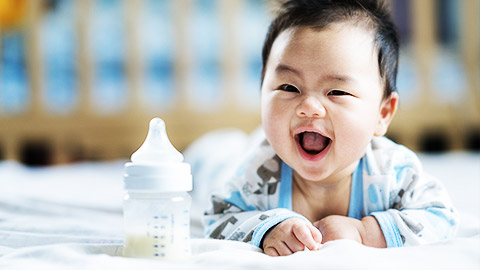 A baby with a milk bottle