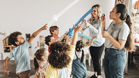 2 childcare workers doing activities with a group of kids