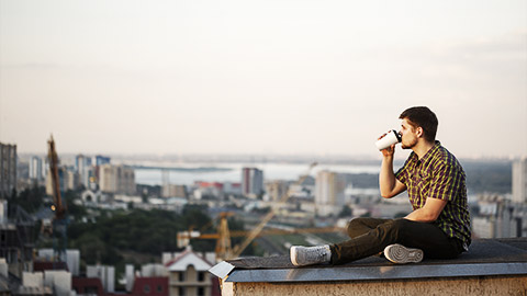 A person drinking coffee on a rooftop