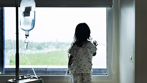 An IV tethered child looking out the window