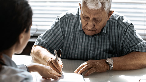 Elder signing paper