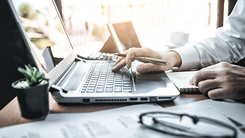 hand on computer and notes