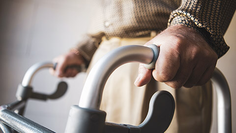 A close view of an elderly person using a walking frame