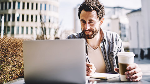 a person jotting down a schedule from an email in his laptop