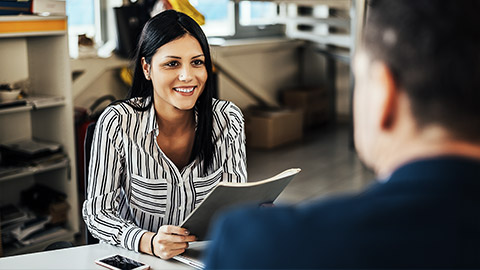 A person giving feedback with an employee in office