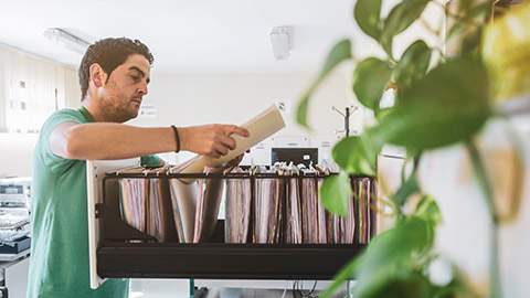 A worker taking client information files out of a filing cabinet