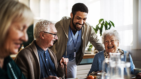 a care taker laughing with old people