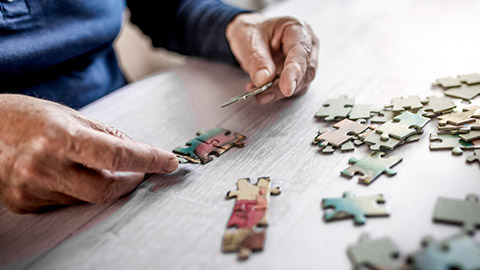 man connecting jigsaw puzzle