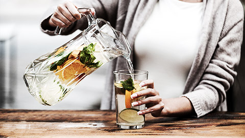 A person pouring healthy fruit drinks