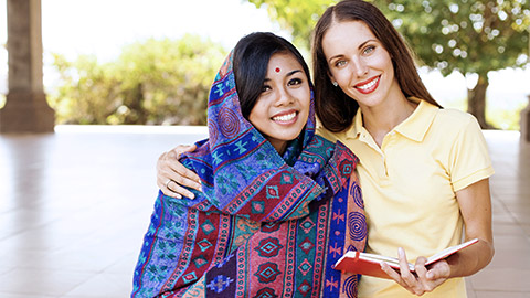 Caucasian and Asian woman smiling to the camera