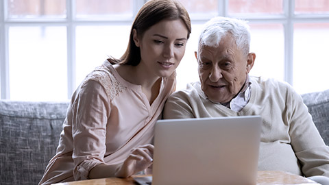 Young woman assisting an elder on computer