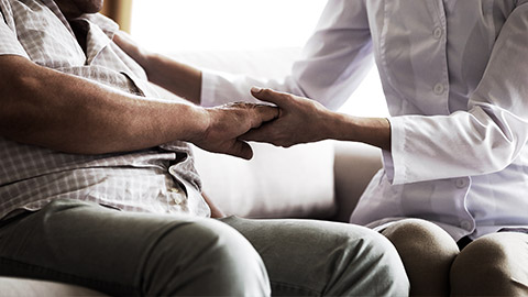 A carer holding an old persons hand