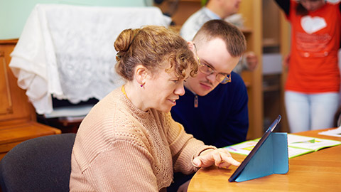 two friends with disability in rehabilitation center, watching digital tablet