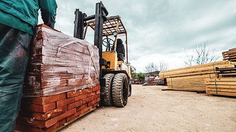 Low view of building supplies being loaded in supply yard