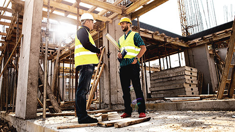 Two construction managers standing on site discussing aspects of the job at hand