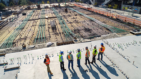 A group of construction managers standing on a site surveying the progress