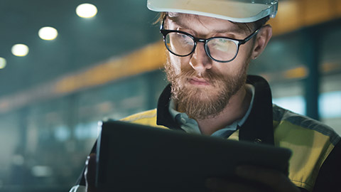 A contractor conducting a video conference on a tablet device while on a worksite