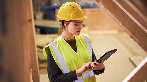 Female site inspector noting defects on worksite